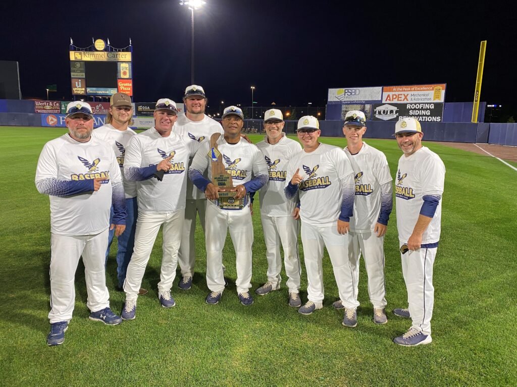 DMA baseball coaches holding championship trophy