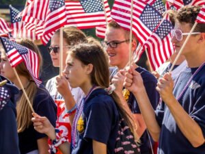 young men and women waving american flags